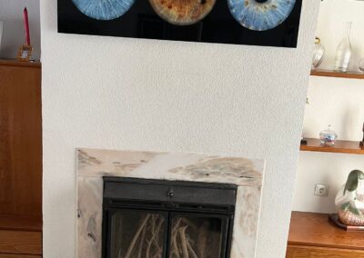 Cuadro familiar de iris en metacrilato en salón con chimenea | mirar.te Madrid